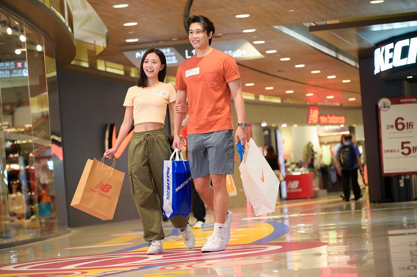A pair of happy couple are shopping in a shopping mall.